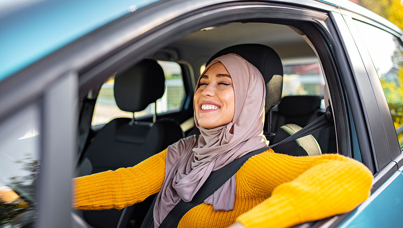 Image of a women sitting in her car relaxed and happy